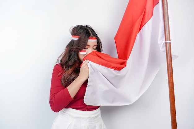 Indonesian woman give salute with proud gesture while holding Indonesia39s flag Indonesia39s independence day concept