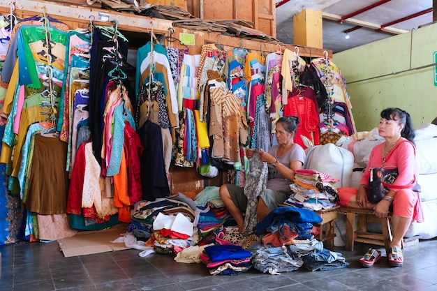 Indonesian woman sorting out her second hand clothes in her thrift store in Bringharjo Market