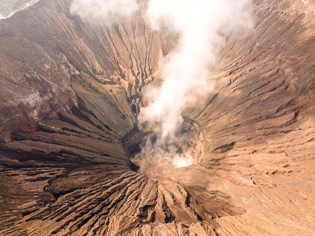 Indonesië. Java-eiland. De actieve vulkaan Bromo. Luchtfoto van de hellingen van de krater en rook