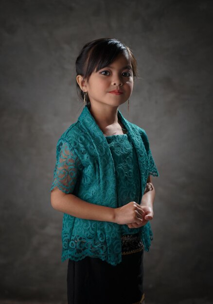 Indonesische kinderen die Kebaya dragen, zijwaarts staan en glimlachen naar de camera Indonesische modestijl