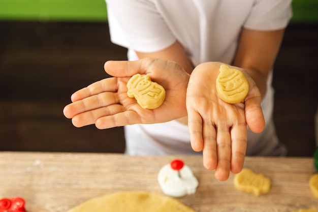 Indoor activity: young child boy cooking in the kitchen. Home cooking. Making cakes or biscuits. Closeup