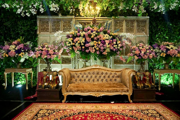 indoor decoration set up for javanese wedding with a lot of fresh flowers