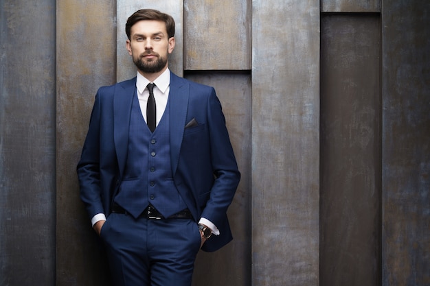 Indoor photo of young handsome stylish businessman wearing suit