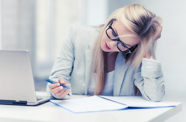 indoor picture of bored and tired woman taking notes