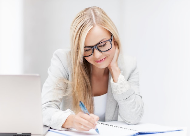 indoor picture of smiling woman with documents and pen