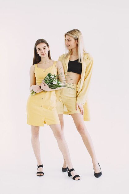 Indoor portrait of two sisters having fun on photoshoot. 