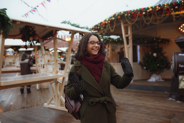 Indoor portret van mooi meisje in rode winterjas die sneeuw blaast op christmas fair kerstvakantie concept kopieer ruimte moskou rode plein