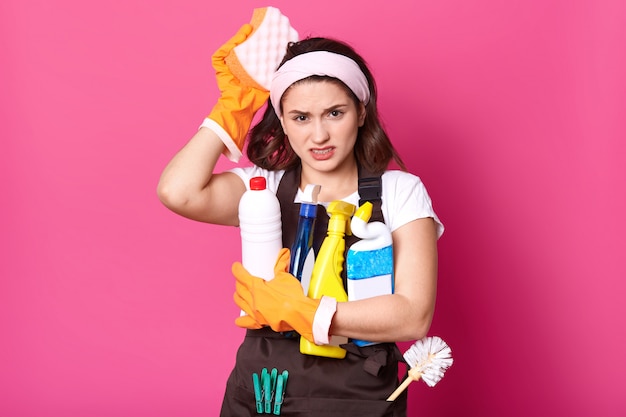 Indoor shot of Caucasian young woman with unpleasant facial expressions