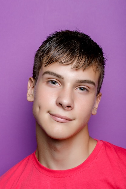 Indoor shot of handsome muscular guy with positive expression, wears casual mock up white t shirt for your promotion, stands against purple background, free space aside. People and emotions. smile