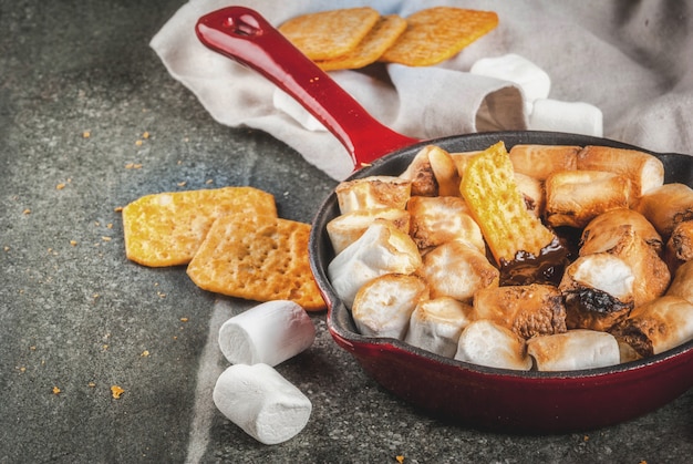 Indoor smores, baked smores dip in a cast iron skillet pan with graham crackers