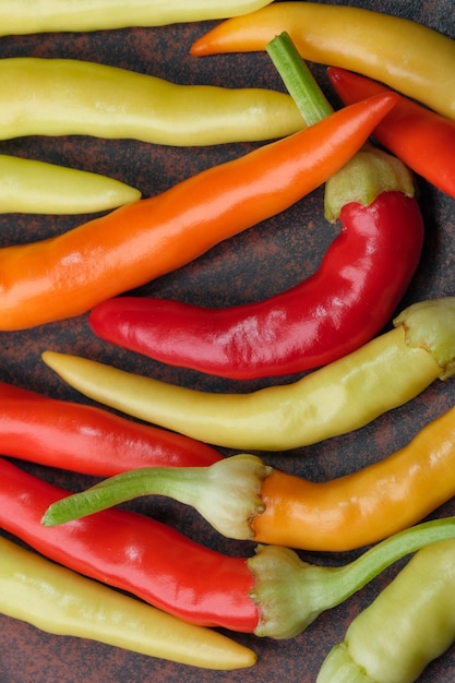 Indoor variety multicolored hot bitter pepper on a brown clay plate close-up macro photography