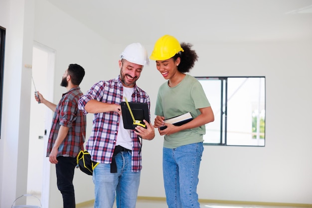 Indoors Painter with roller and color palette Young african american woman and hispanic construction worker smiling builder people