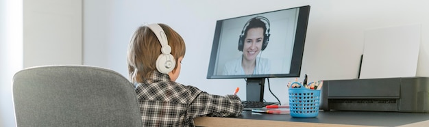 Photo indoors school boy taking online courses