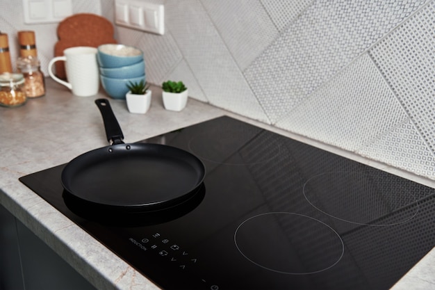 Фото Индукционная плита с кастрюлей на ней современный кухонный прибор