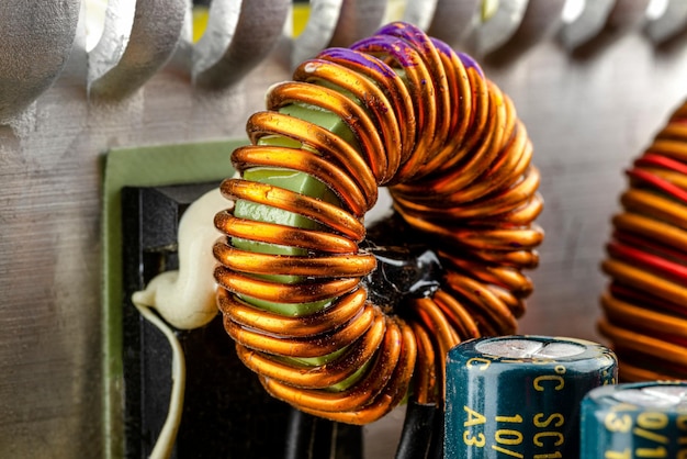Foto una bobina toroidale dell'induttore su un anello con un rotolo di rame visibile avvolto su una bobina magnetica