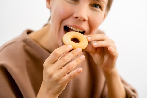 Indulging in guilty pleasures An attractive middleaged woman enjoying a chocolatecovered donut