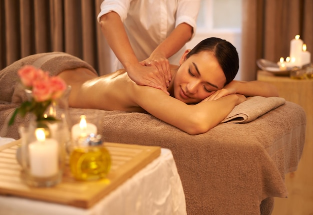 Indulging her senses at the spa A beautiful young woman enjoying a massage at the spa