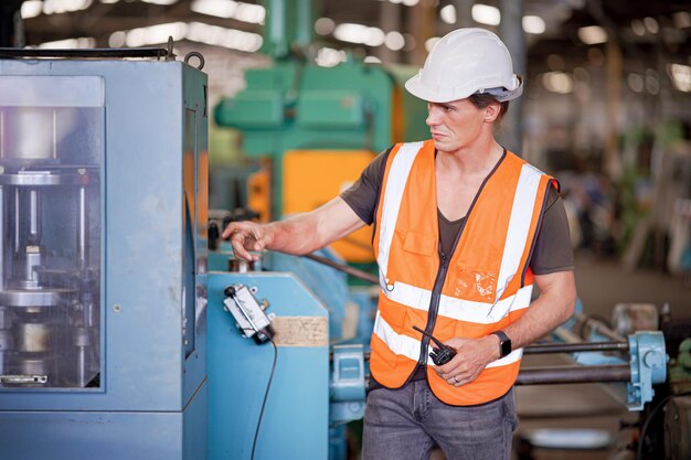 Industrial background of caucasian mechanics engineer operating lathe machine for metalwork in metal work factory