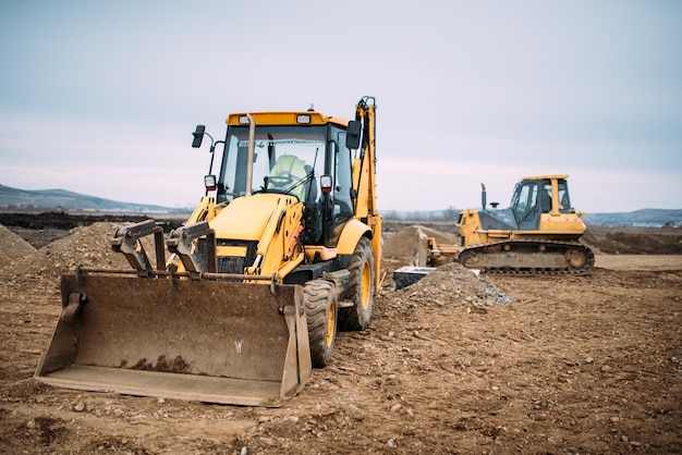 Foto escavatore a cucchiaia rovescia industriale e macchinari per bulldozer in cantiere