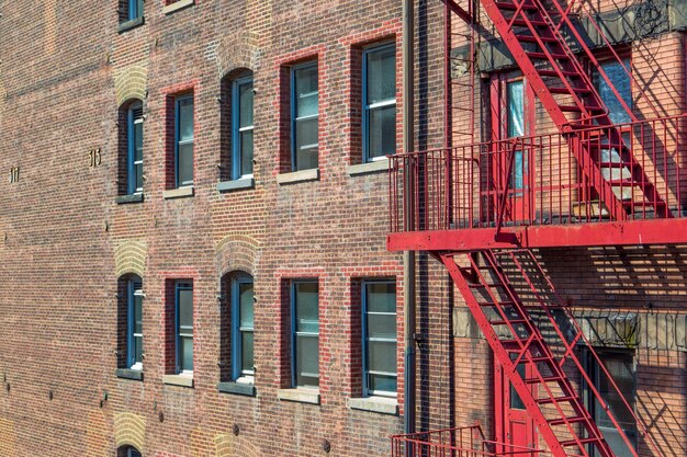 Industrial brick building seen with a red fire escape ladder