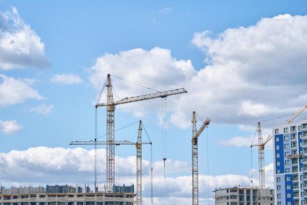 Industrial building cranes on background of cloudy sky construction site background hoisting cranes