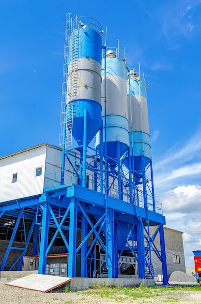 Industrial building with big blue tanks for cement sand water metal stairs leading