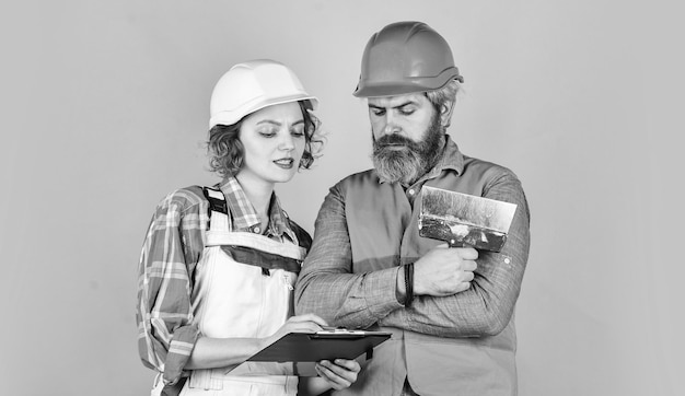 Industrial business partner job and occupation confident electrical and technician engineers couple working together on building blueprint work at construction site or factory Civil engineering