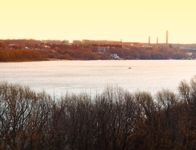 Industrial chimneys on river during sunset background