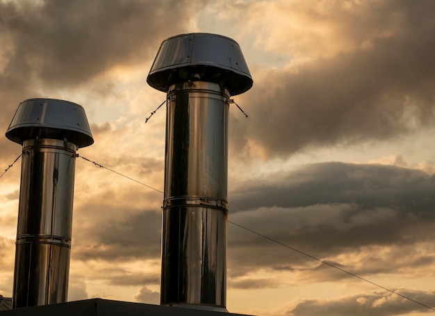 写真 夕暮れの雲の空を背景にした工業用クロムパイプ