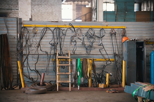 Industrial concept. Constructing lifting crane in the plant. Metal cables on the wall. Mid shot