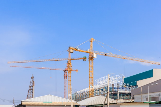 Industrial construction cranes and building in a beautiful blue sky background