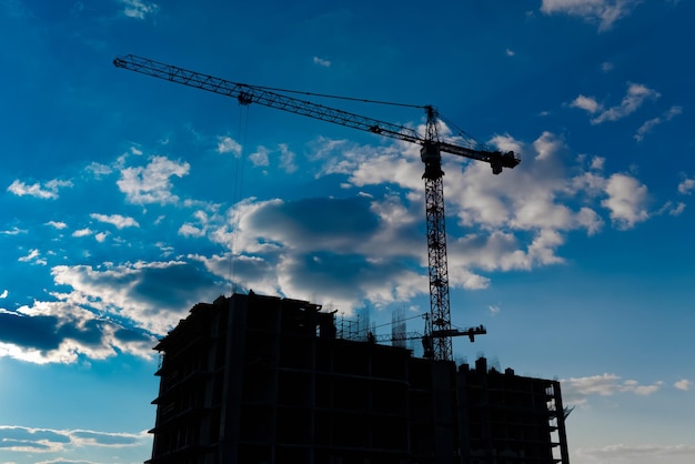 Industrial construction cranes and building silhouettes.