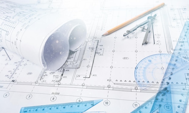 Деталь промышленного чертежа и несколько инструментов для рисования на столе