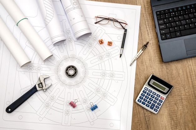 Industrial drawing with different draw tools, calculator and laptop