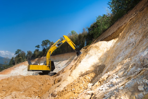 Industrial excavator working on construction site to clear the land of sand and soil