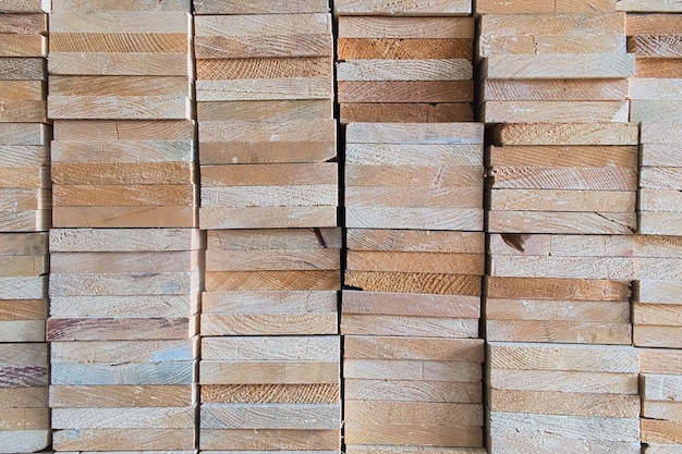 Промышленные головы деревянные прямоугольной формы из распиленного деревянного материала, которые уложены в квадрат на деревянном складе, хранят текстуру древесины и фон
