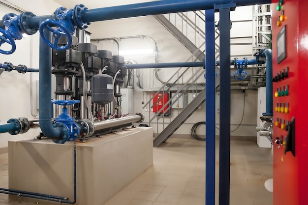 Industrial interior of water pump, valves, pressure gauges,
motors inside engine room. valve and pumps in an industrial room.
urban modern powerful pipelines and pumps, automatic control
systems