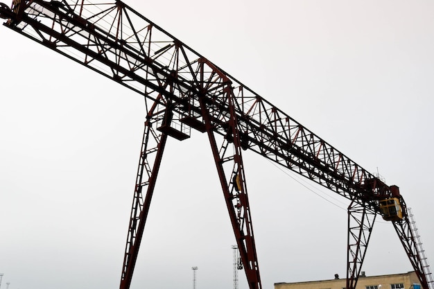 Industrial iron large metal gantry crane with a hook mounted on the supports for lifting