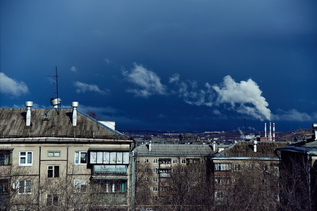 写真 都市の冶金工場の産業景観。住宅、青空を背景にパイプを吸う