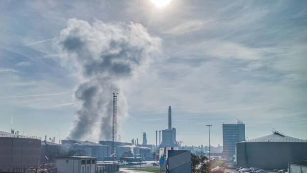 Industrial landscape with strong atmosphere wastes emission above large power plant or factory on a background of cloudy sunny sky in Budapest, Hungary.