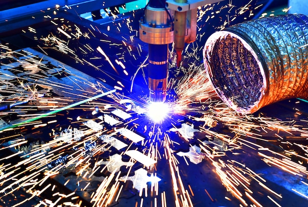 Industrial laser cut machine while cutting the sheet metal with the sparking light.