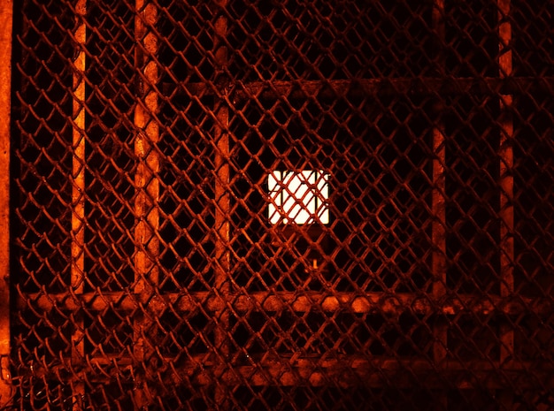 Photo industrial metal cage illuminated by light background