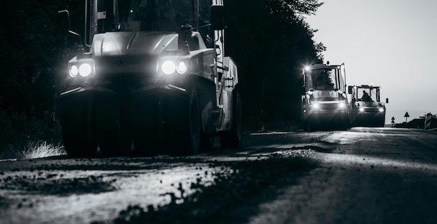 Industrial pavement truck is laying fresh asphalt on\
construction site road service repairs the hig