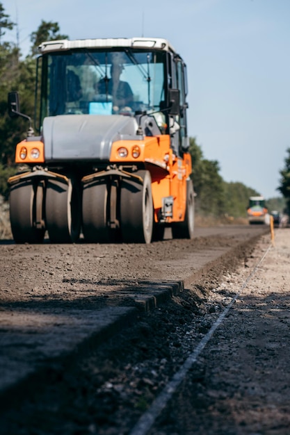 Industrial pavement truck is laying fresh asphalt on construction site Road service repairs the hig