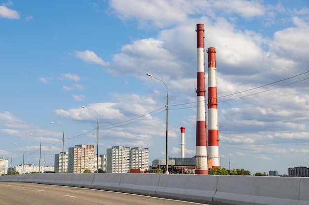 Industrial plant with tall chimneys against the blue sky