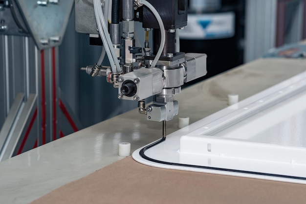 産業用ロボット投薬ディスペンサー マシンは、金属製のドア ブランクに硬化シーラントを適用します。