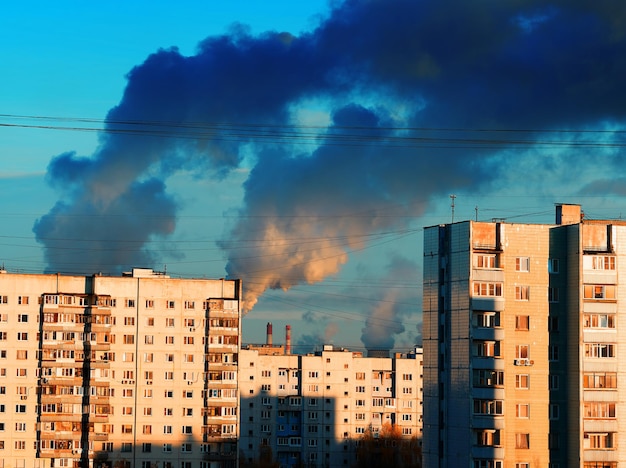 Промышленный дым над архитектурой пригорода