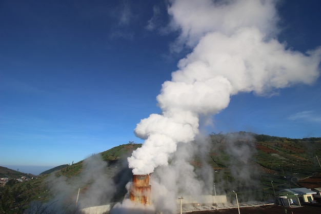 Industrial smoke from the chimney under the blue sky