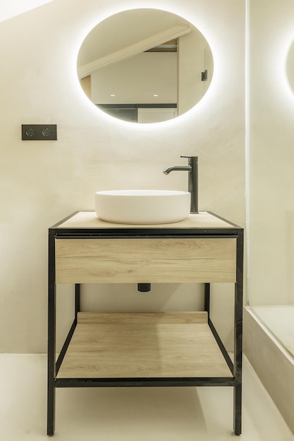 Industrial style bathroom sink cabinet made of wood and iron with circular mirror