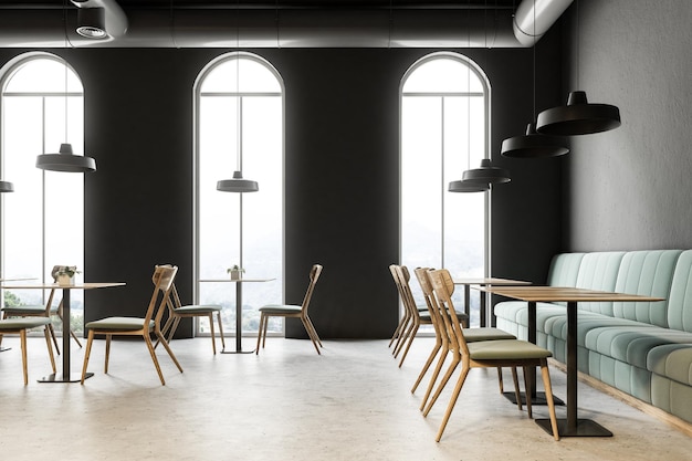 Foto ristorante caffetteria in stile industriale con pareti grigio scuro, pavimento in cemento, finestre ad arco e tavoli in legno con sedie. divani verdi. rendering 3d mock up